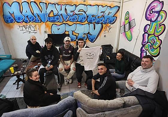 Gaizka Carnero, con la camiseta de PuntoNorte920 en las manos, y varios miembros más de su cuadrilla en la lonja de Portugalete.