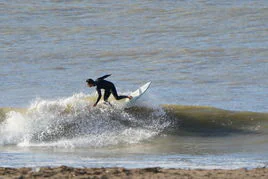 Un surfista toma una ola en la playa de Ereaga.