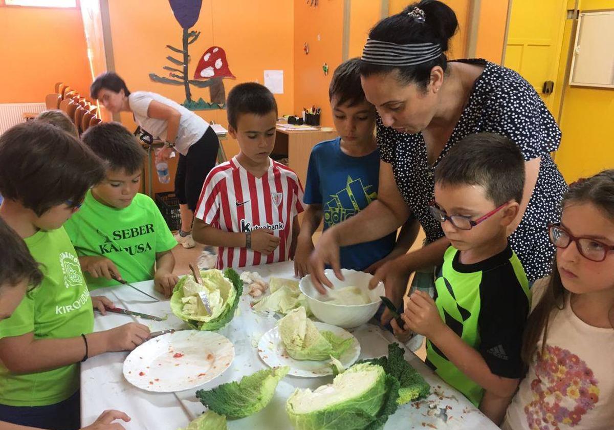 Una mujer magrebí imparte un taller de cocina a niños de Gernika.