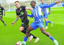 El albiazul Doumbia pugna con el capitán del Barbastro, Carlos Gasgo.