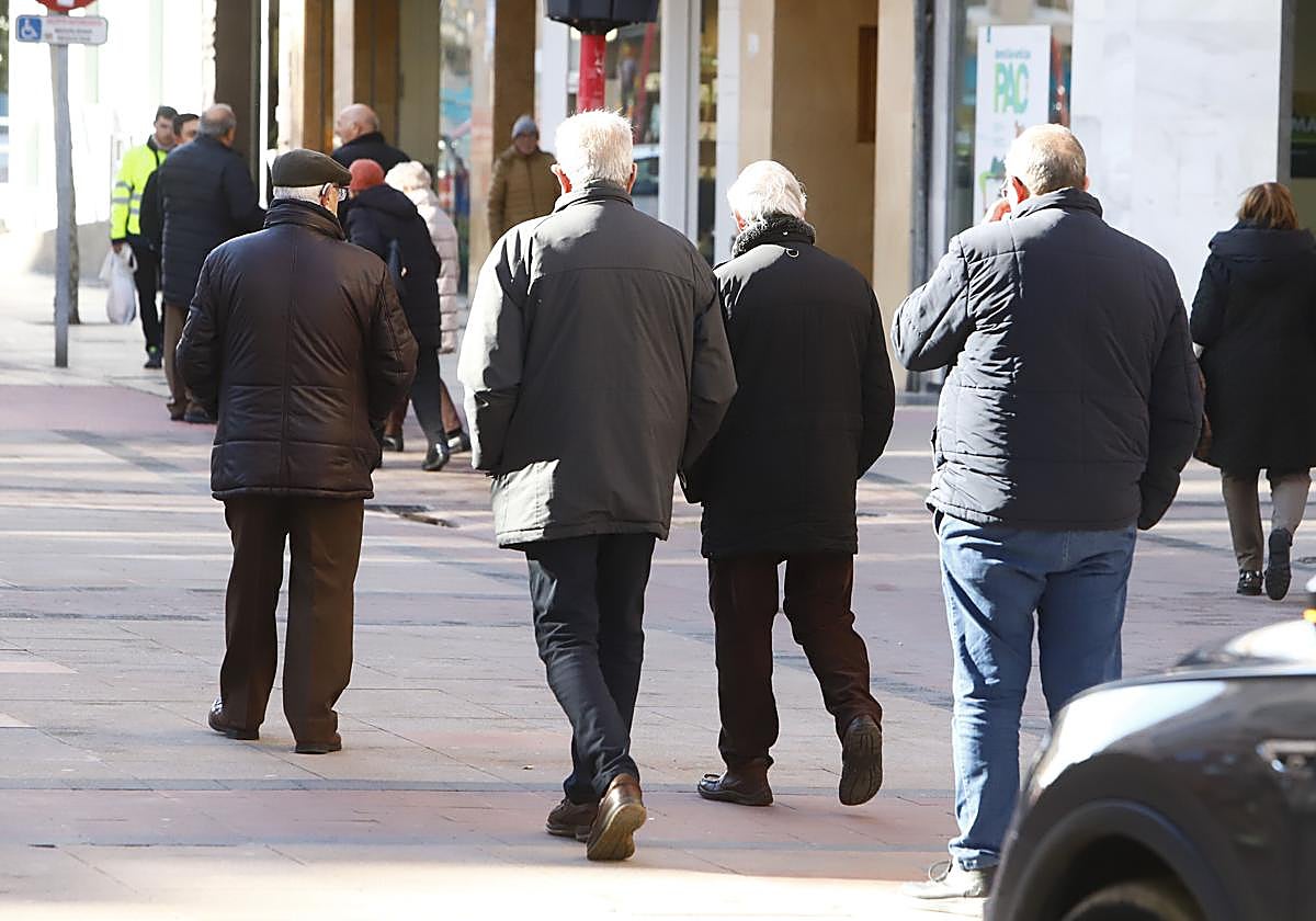 Un grupo de jubilados pasea por una calle.