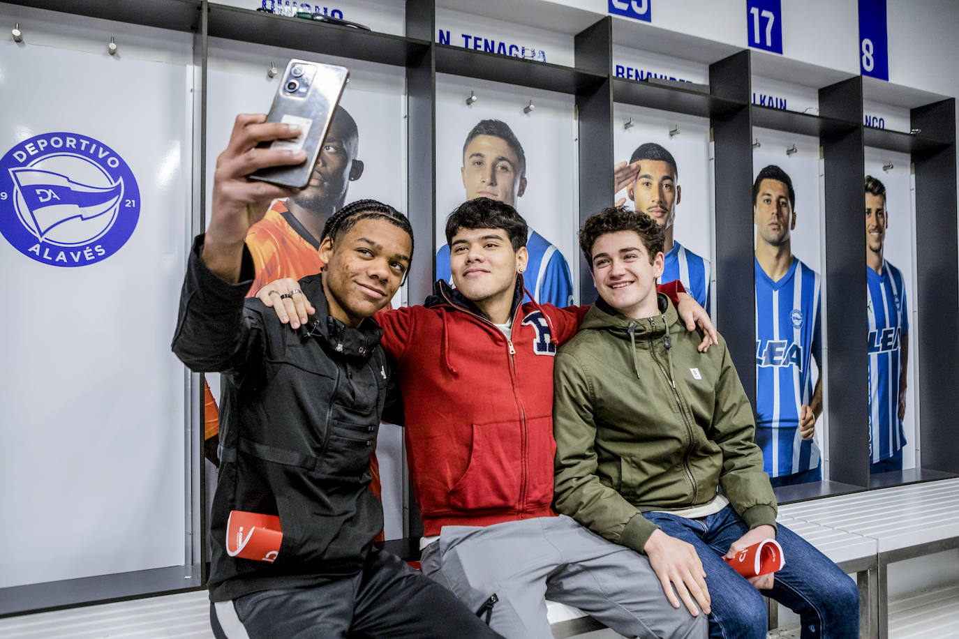 Tres jóvenes se sacan un selfi en el vestuario del Alavés en Mendizorroza.