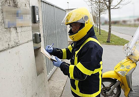 Un cartero de Correos, ajeno a esta información, se dispone a realizar una entrega a domicilio.