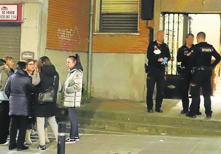 Vecinos del barrio de El Kalero, en Basauri, aguardan a la puerta del bloque de viviendas donde se encontró a madre e hijo.