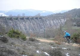 Un ciclista pasa frente a las compuertas de Ullibarri.
