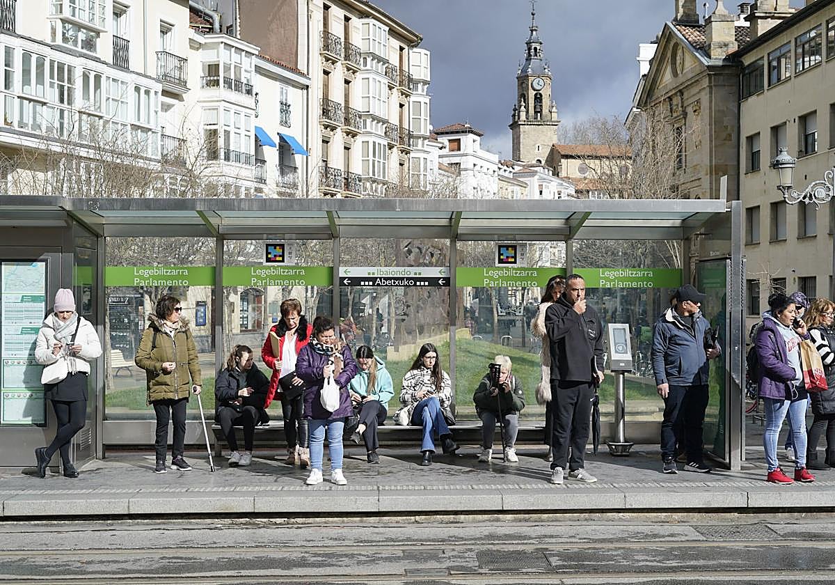 Varios ciudadanos esperan la llegada del tranvía en la parada de Parlamento.