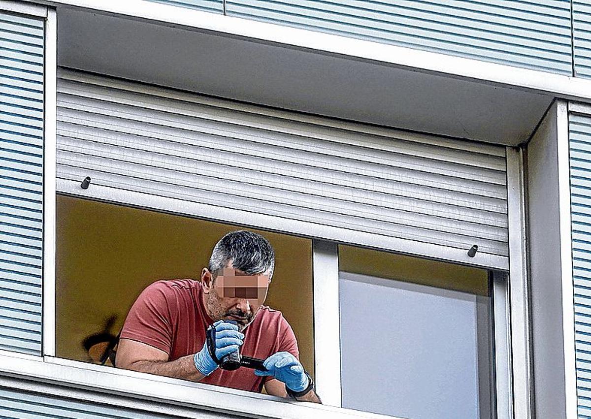 Imagen secundaria 1 - Un agente uniformado acompaña a una familiar del pequeño de 11 meses, mientras que otro graba desde la ventana donde ocurrieron los hechos. Un policía fotografía el lugar del impacto junto al pañal del bebé.