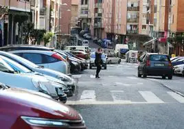 Varios coches aparcados en las dos calzadas de una calle del barrio de Astrabudua.