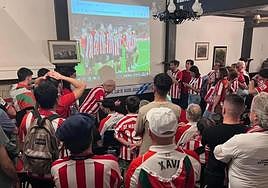 Aficionados rojiblancos siguen el partido en un local.