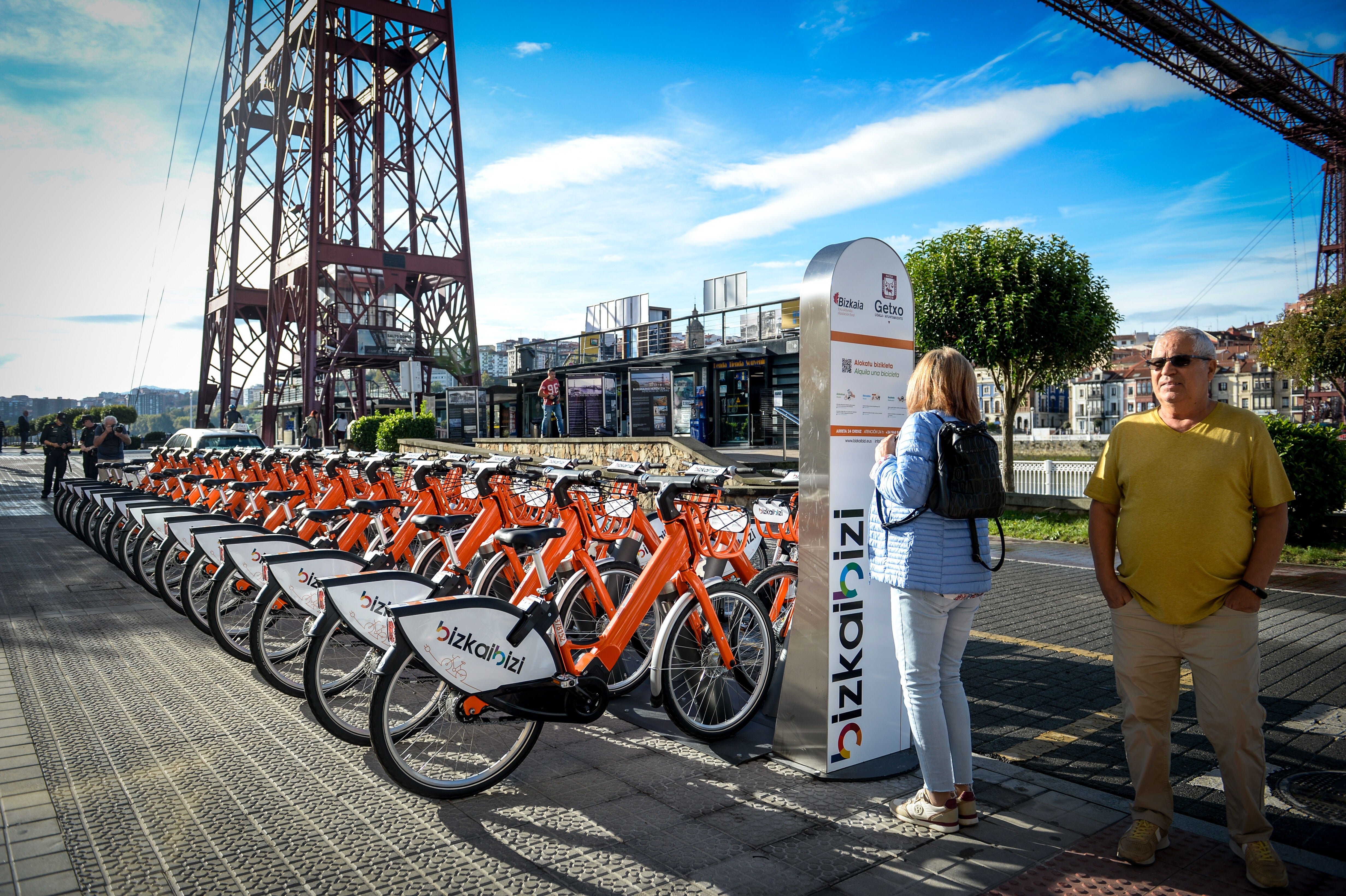 Una mujer consulta las condiciones del servicio de alquiler de bicicleta eléctrica.