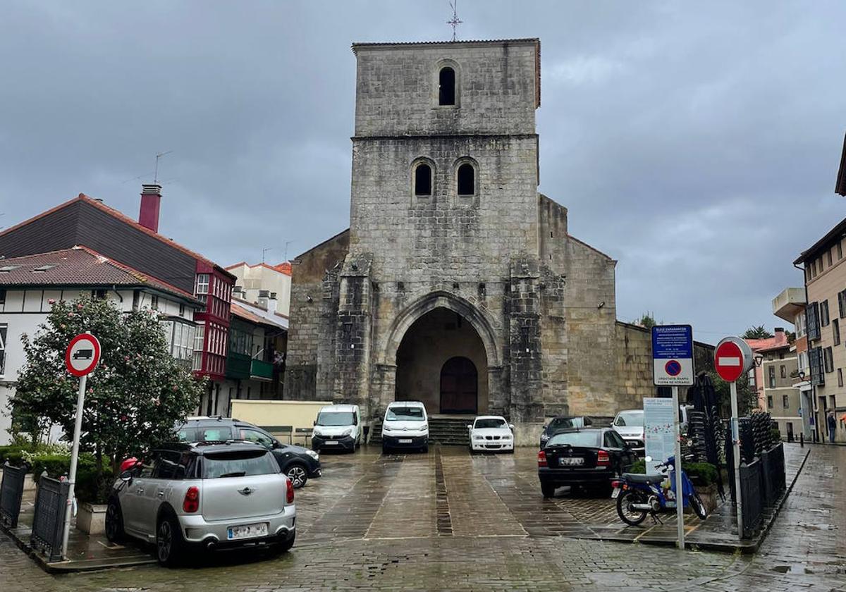 Varios coches aparcados en la plaza de la iglesia Santa María Magdalena en Plentzia.