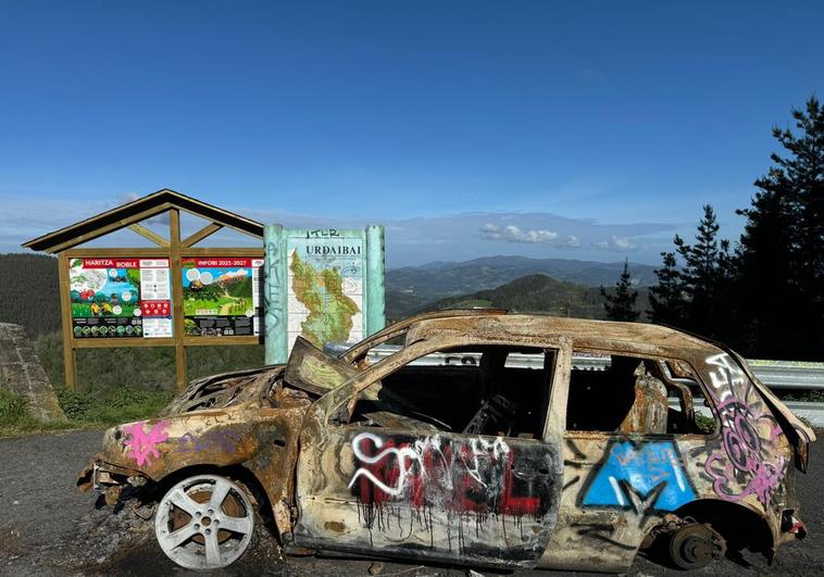 El vehículo abandonado está inmovilizado por un cepo y repleto de pintadas en plena puerta de entrada a Urdaibai.