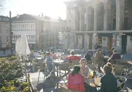 Varias personas disfrutan del sol en una terraza de Vitoria.