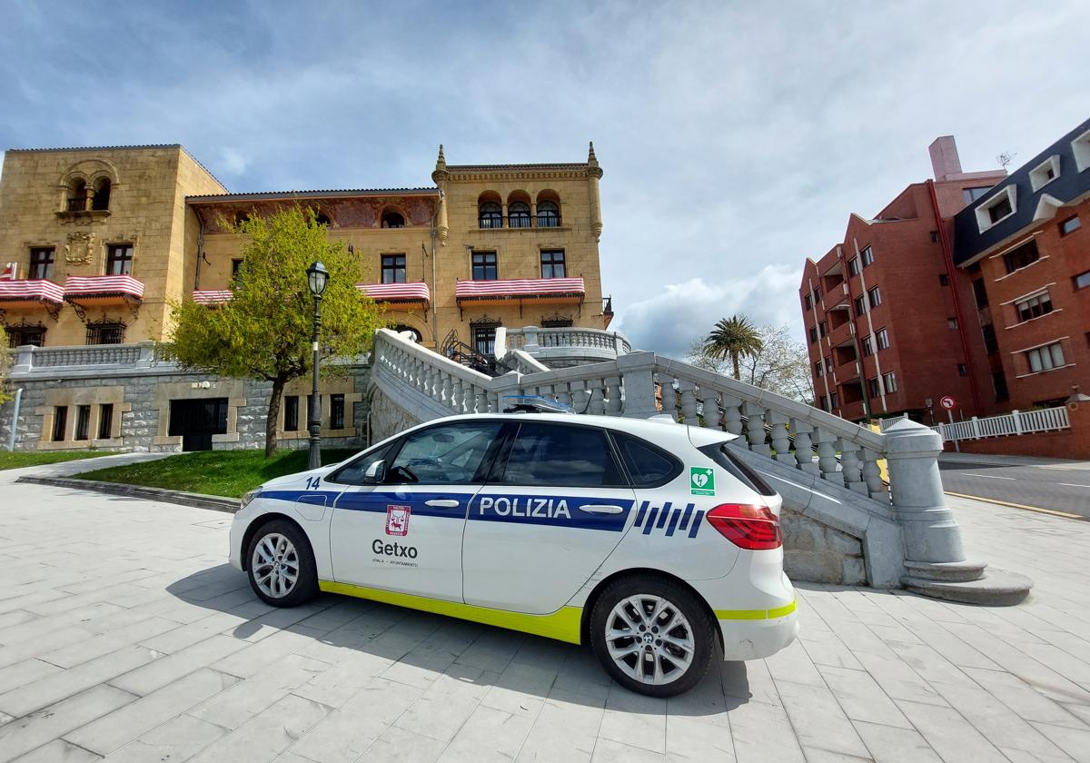 Imagen de un coche de la Guardia Urbana frente al Ayuntamiento engalanado con la bandera rojiblanca