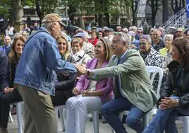 Un asistente al mitin en Vitoria saluda al candidato a lehendakari del PP, Javier de Andrés, en presencia de Cuca Gamarra.