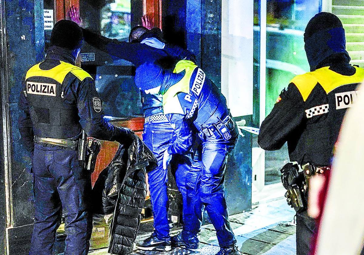 Policías locales cachean a un joven en una calle de Vitoria.