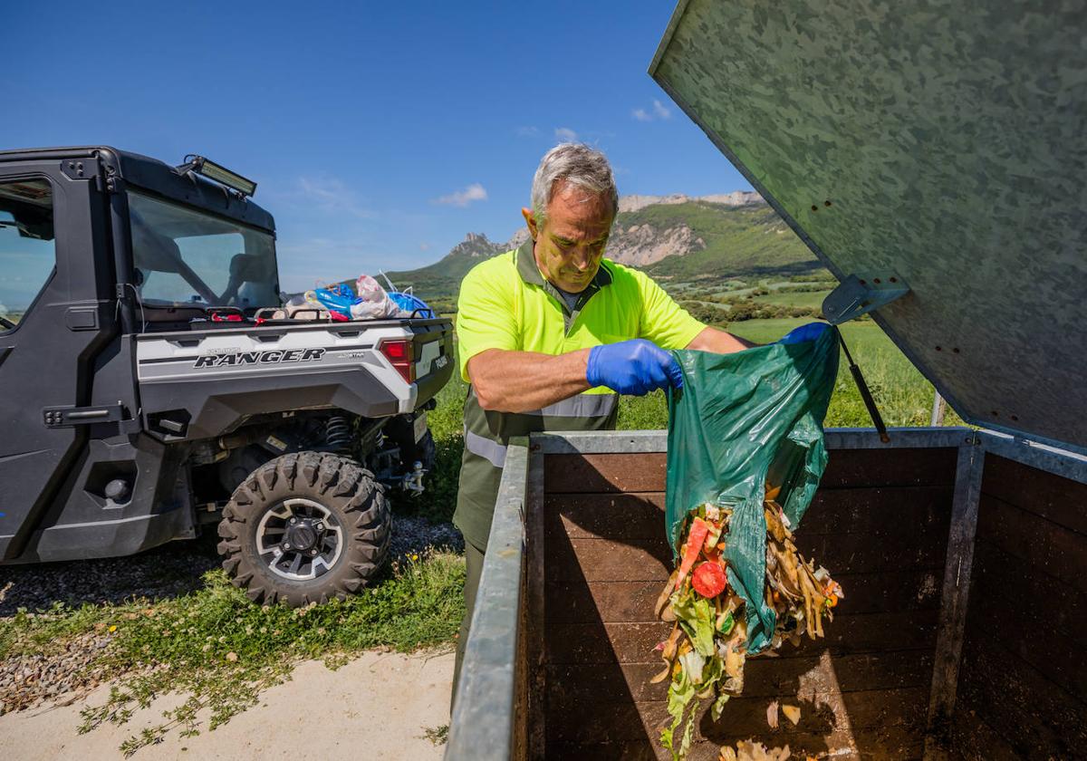 Un operario deposita restpos orgánicos en un compostador de Kripán.