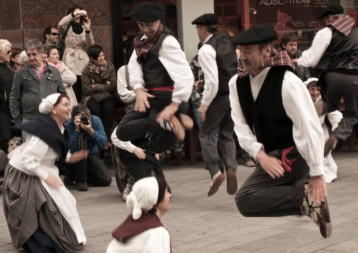 Imagen secundaria 1 - Un montañero en una cima., los dantzaris bailando por las calles del centro de Vitoria y exposición de setas y hongos en la Plaza de España. 