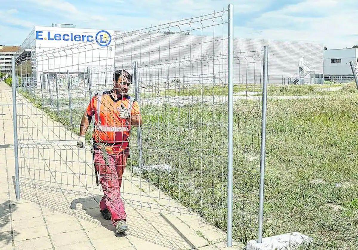 Un operario coloca vallas en la parcela en la que Orpea construirá la nueva residencia de Zabalgana.