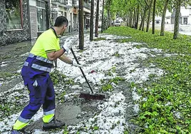 Un trabajador retira granizo y hojas de la plaza de los Fueros.