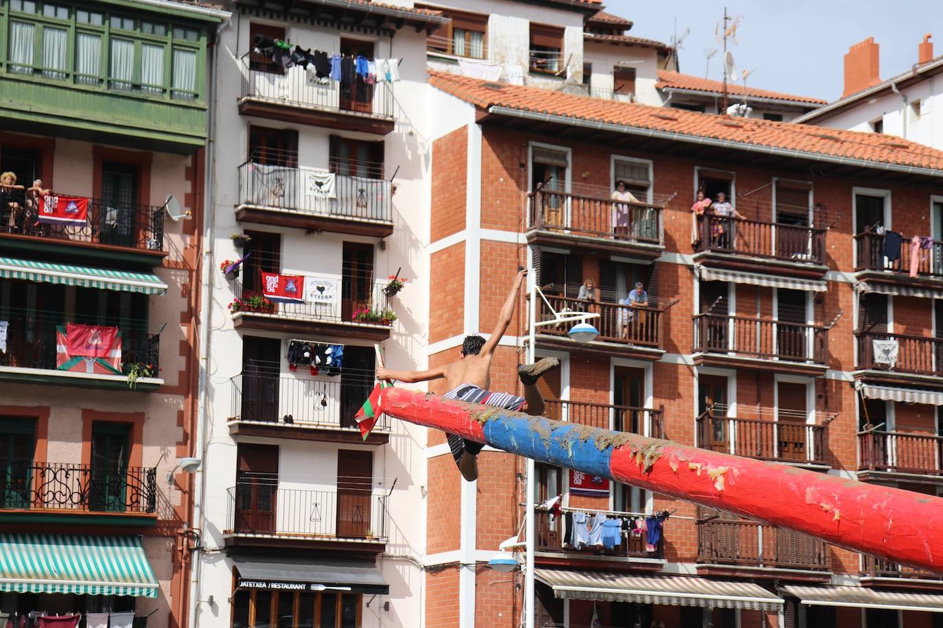 Un joven logra la bandera al final de la cucaña de Ondarroa.