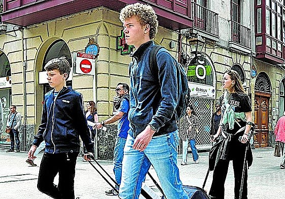 Turistas cargan con sus maletas por el Casco Viejo de Bilbao.