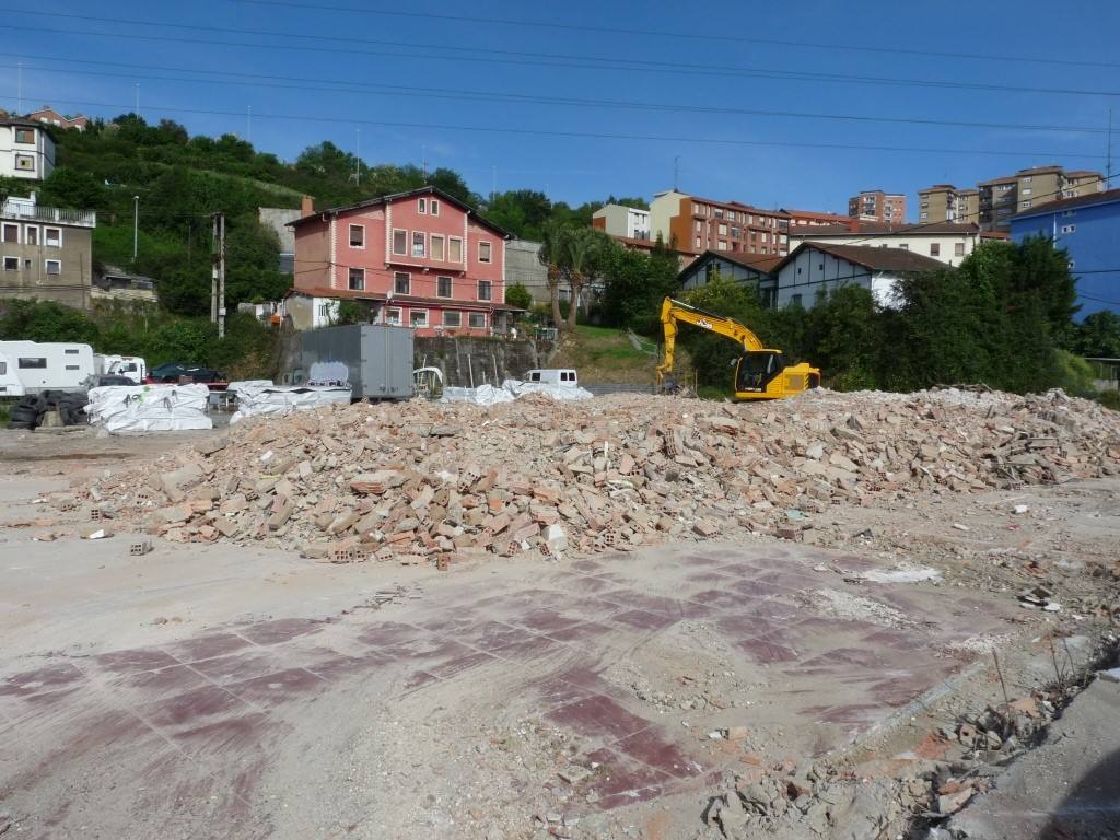 Parte del material de las naves derribadas, junto a una excavadora, en el barrio de Lutxana.