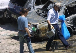 Dos agentes, recogiendo material en el lugar del atentado de ETA en Sangüesa en 2003.