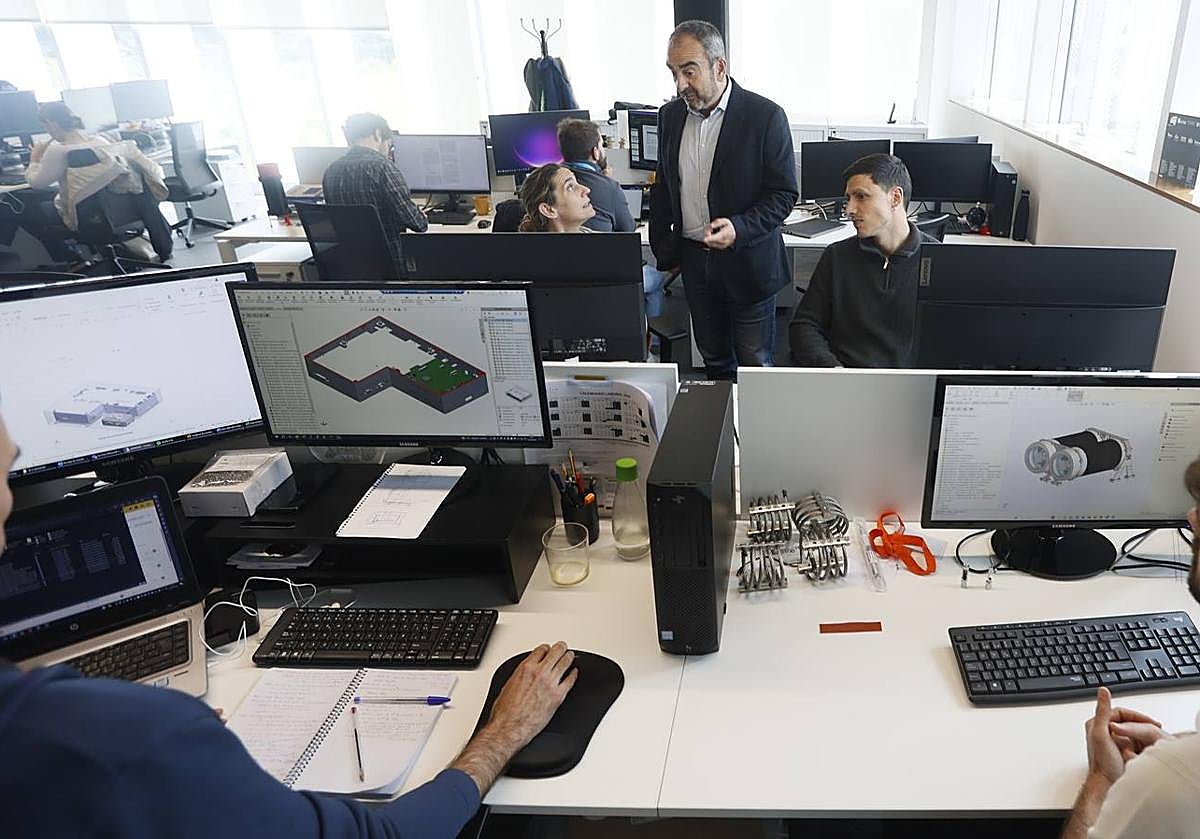 Imagen principal - Juan Tomás Hernani junto a su plantilla de ingenieros electrónicos.