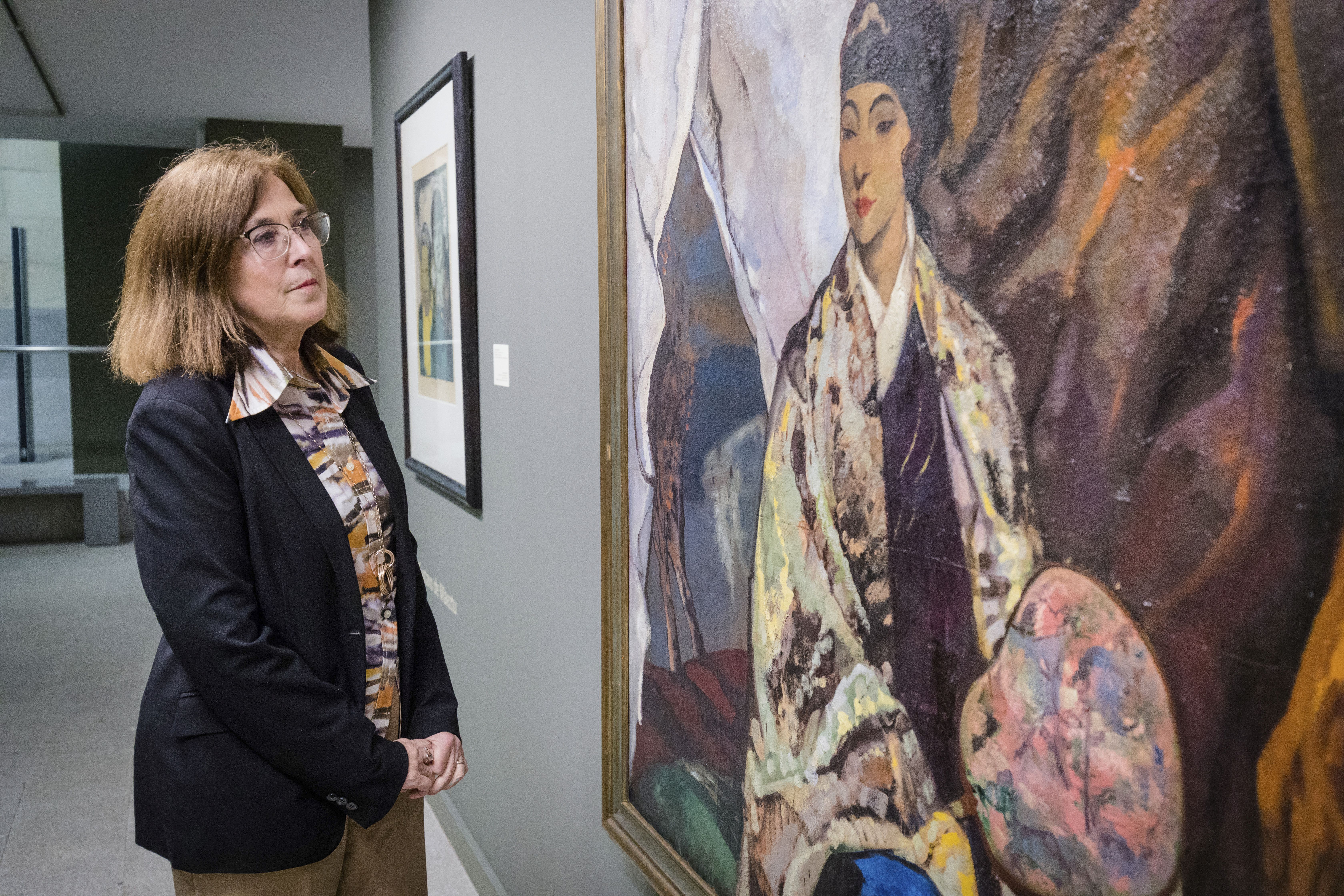 Sara González de Aspuru, directora del Bellas Artes de Álava, junto a la obra 'Mongoles', de Gustavo de Maeztu.