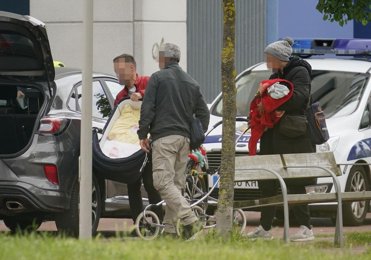 Dos policías locales de paisano colocan el carrito de la familia en un coche camuflado.