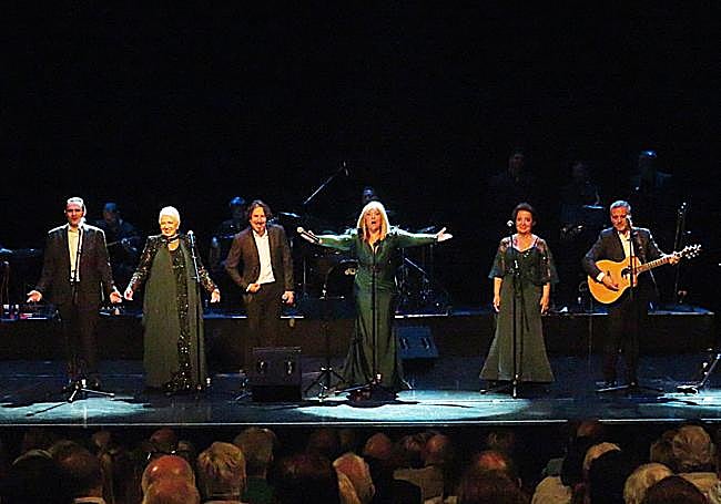 Rosa Rodríguez iluminada entre los seis de Mocedades.