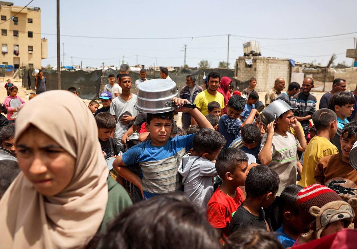 Niños palestinos desplazados esperan para recibir comida en Rafah en una imagen tomada esta semana.