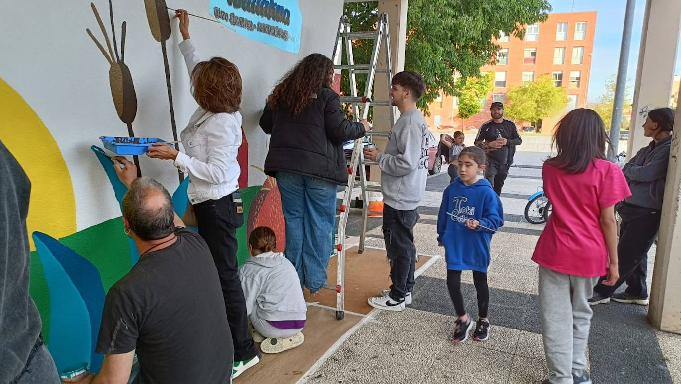 En imágenes: 150 vecinos de Ibaiondo pintan un mural de 24 metros