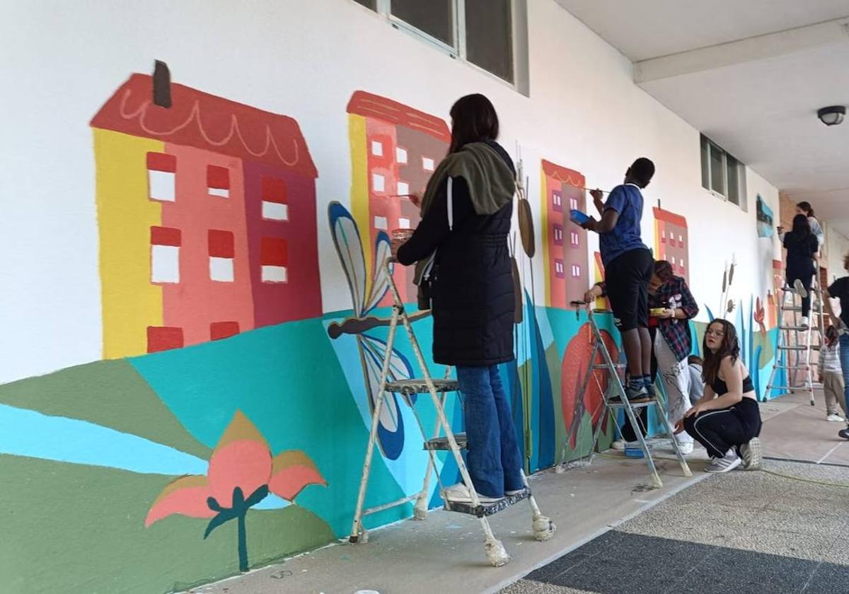 En imágenes: 150 vecinos de Ibaiondo pintan un mural de 24 metros