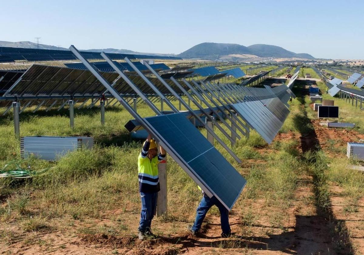 Dos operarios instalan placas en Ekian, el parque solar más grande de Euskadi, ubicado en Ribera Baja