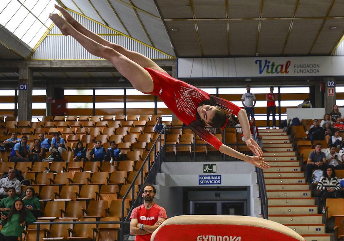 Una gimnasta vuela por los aires durante un ejercicio.