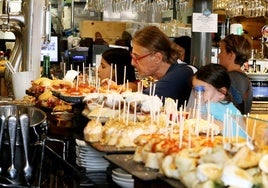 Turistas ante la barra de pintxos de un bar del casco viejo de Bilbao