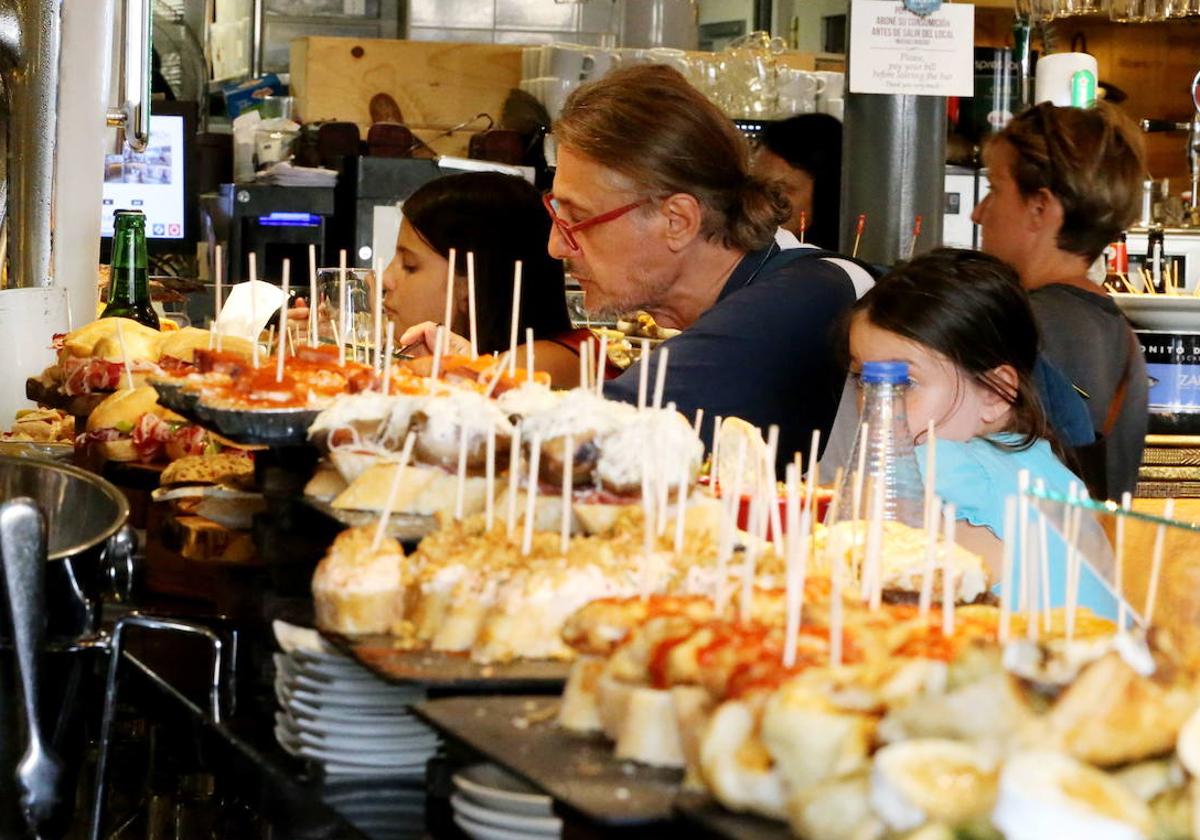 Turistas ante la barra de pintxos de un bar del casco viejo de Bilbao