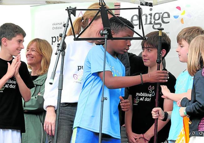 Un alumno de Urdaneta entrega el testigo a otro de la localidad vizcaína de Orduña, donde se celebrará la próxima fiesta de la escuela pública vasca.