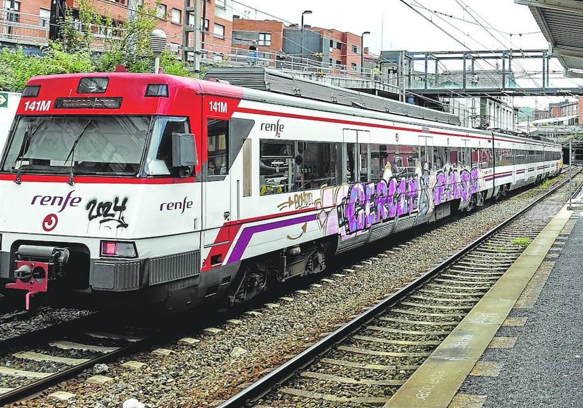 Una unidad de la serie 446 de Cercanías Bilbao se detiene en la estación de Barakaldo, luciendo un enorme grafiti en uno de sus costados.