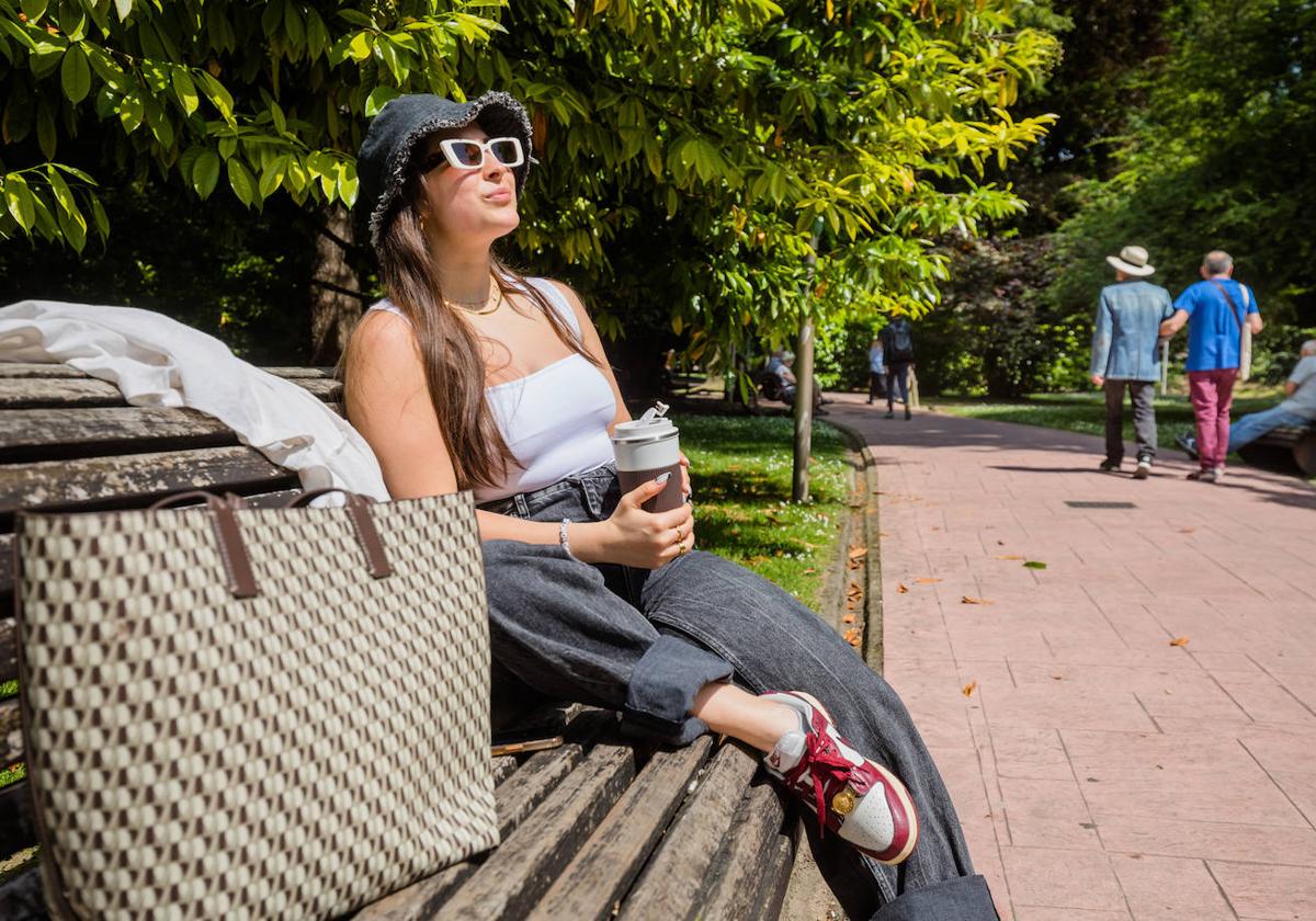 Una mujer toma el sol en un parque de Vitoria.