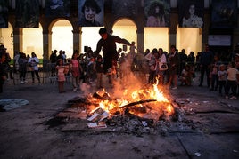 Un joven salta la hoguera de la plaza de San Nicolás en Algorta.