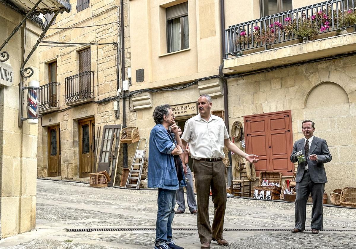 Imagen principal - Figurantes se mueven por las calles de la villa de Rioja Alavesa ante un gran despliegue técnico dy de profesionales del cine.