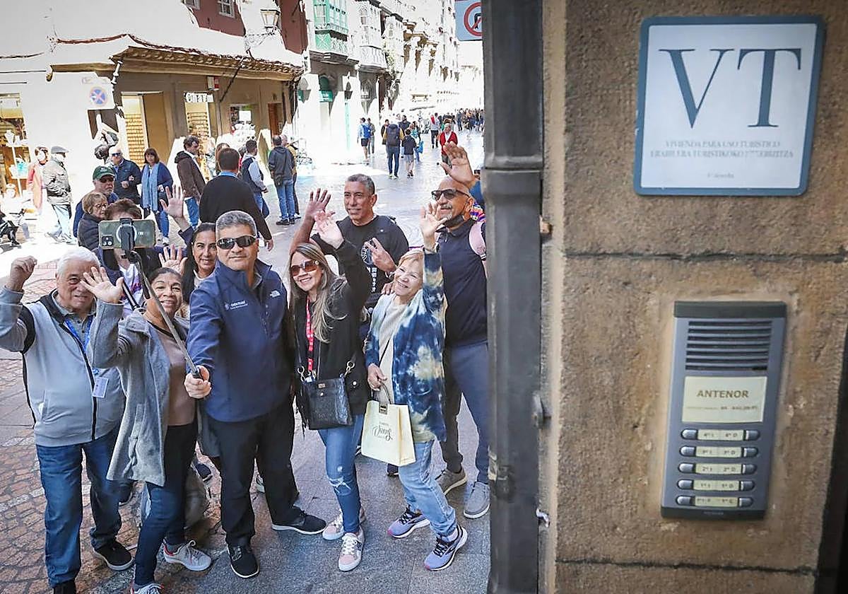Turistas se hacen un selfie ante un piso turístico.