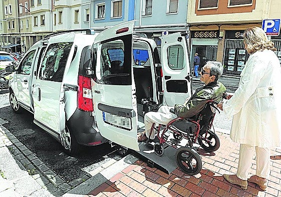 Esther, usuaria habitual de taxi adaptado, introduce a su marido, Santiago, en su coche adaptado.