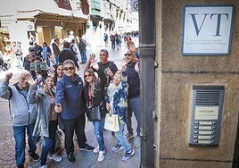 Turistas se hacen un selfie junto a un apartamento turístico.