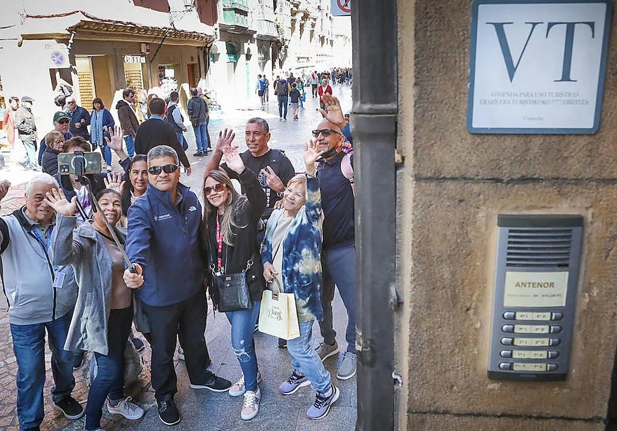 Turistas se hacen un selfie junto a un apartamento turístico.