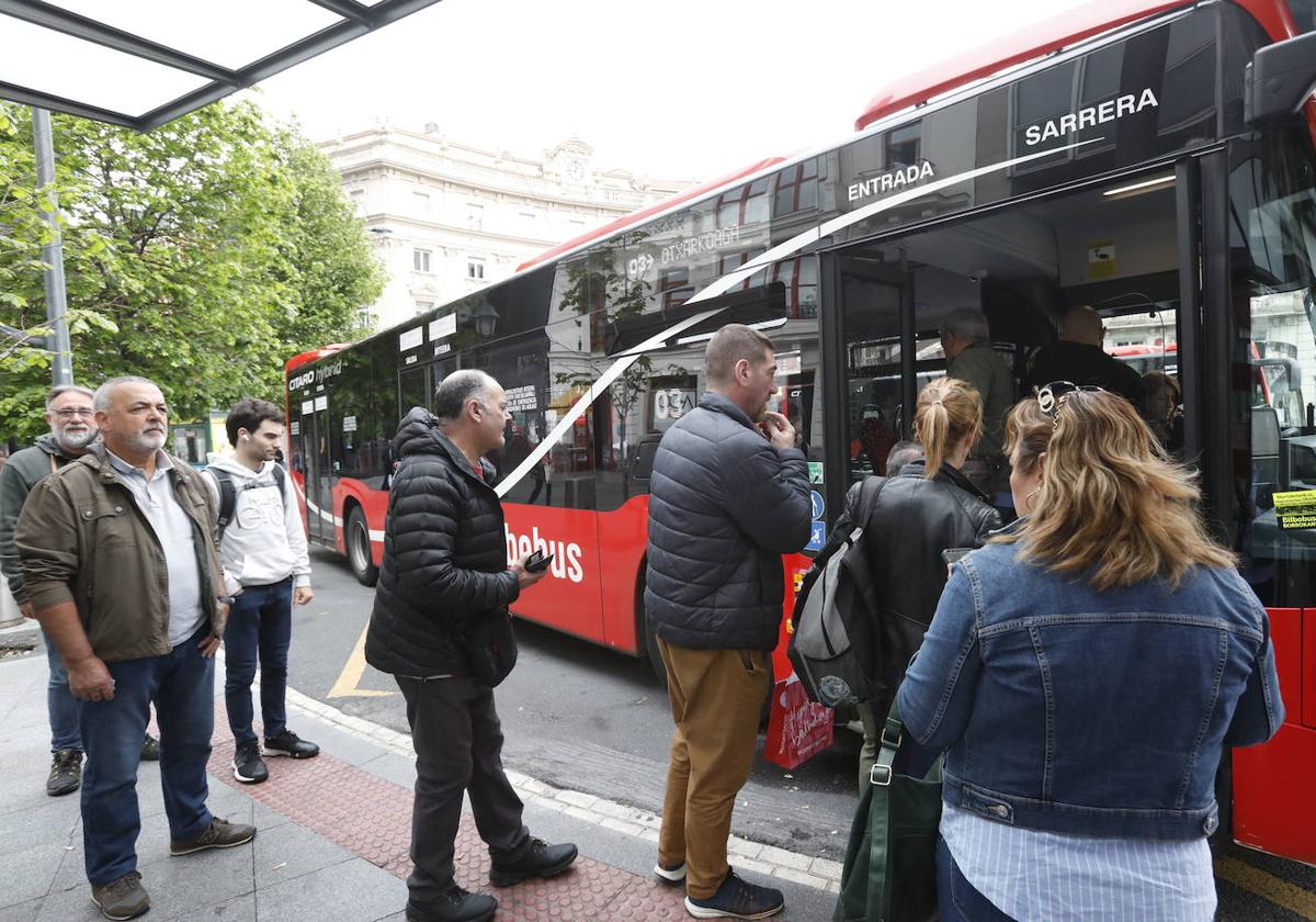 Pasajeros esperan para subir a un autobús.