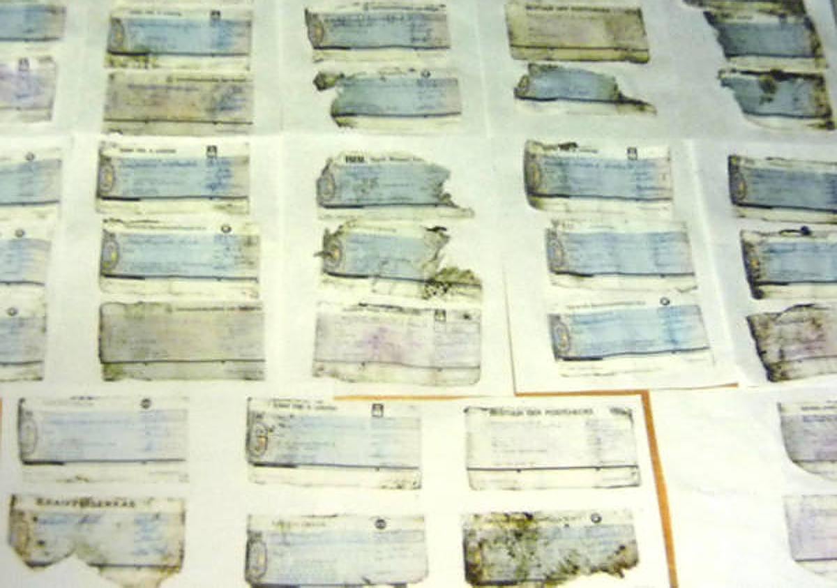 Imagen secundaria 1 - En las imágenes, dos vehículos incendiados por los asesinos de Brabante en sus fugas y unos cheques robados por los criminales que fueron encontrados en un canal belga.